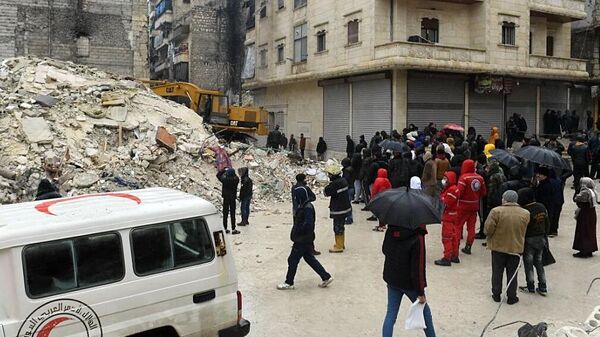 Люди наблюдают за строительной техникой во время разбора завалов разрушенного в результате землетрясения жилого дома в сирийском Алеппо, 7 февраля 2023 года - Sputnik Казахстан