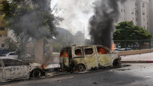 Сгоревшие автомобили после прилета ракеты из сектора Газы в израильский город Ашкелон - Sputnik Қазақстан