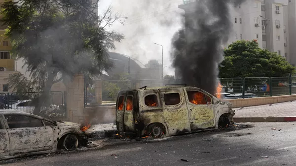 Сгоревшие автомобили после прилета ракеты из сектора Газы в израильский город Ашкелон - Sputnik Казахстан