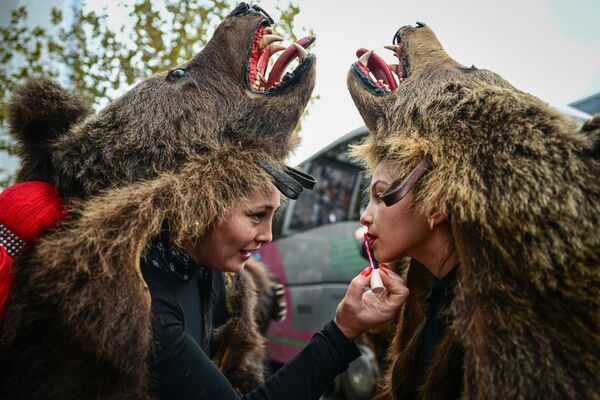 Женщина накладывает макияж на губы перед началом второго Международного фестиваля зимних традиций в Бухаресте, Румыния. - Sputnik Казахстан