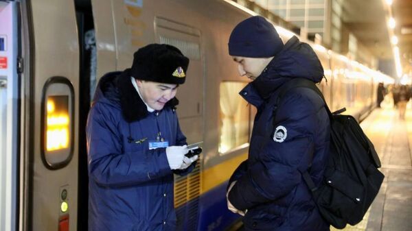 Проводник проверяет документы и билеты у пассажира на станции  - Sputnik Казахстан