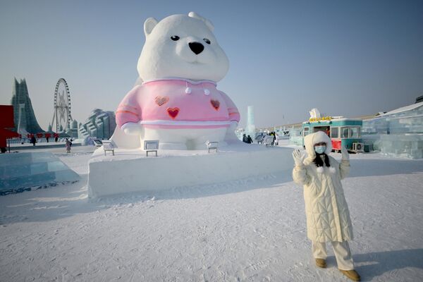 Фестиваль в Харбине является крупнейшим в мире. Десятками огромных ярких и разноцветных ледяных скульптур любуются посетители.На фото: женщина позирует на выставке Harbin Ice and Snow World в Харбине. - Sputnik Казахстан