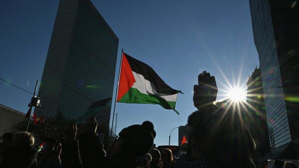Пропалестинские протестующие проводят демонстрацию возле штаб-квартиры ООН перед голосованием на Генеральной Ассамблее в Нью-Йорке 12 декабря 2023 года. Генеральная Ассамблея ООН собирается проголосовать за необязывающую резолюцию, требующую немедленного гуманитарного прекращения огня в секторе Газа. - Sputnik Казахстан