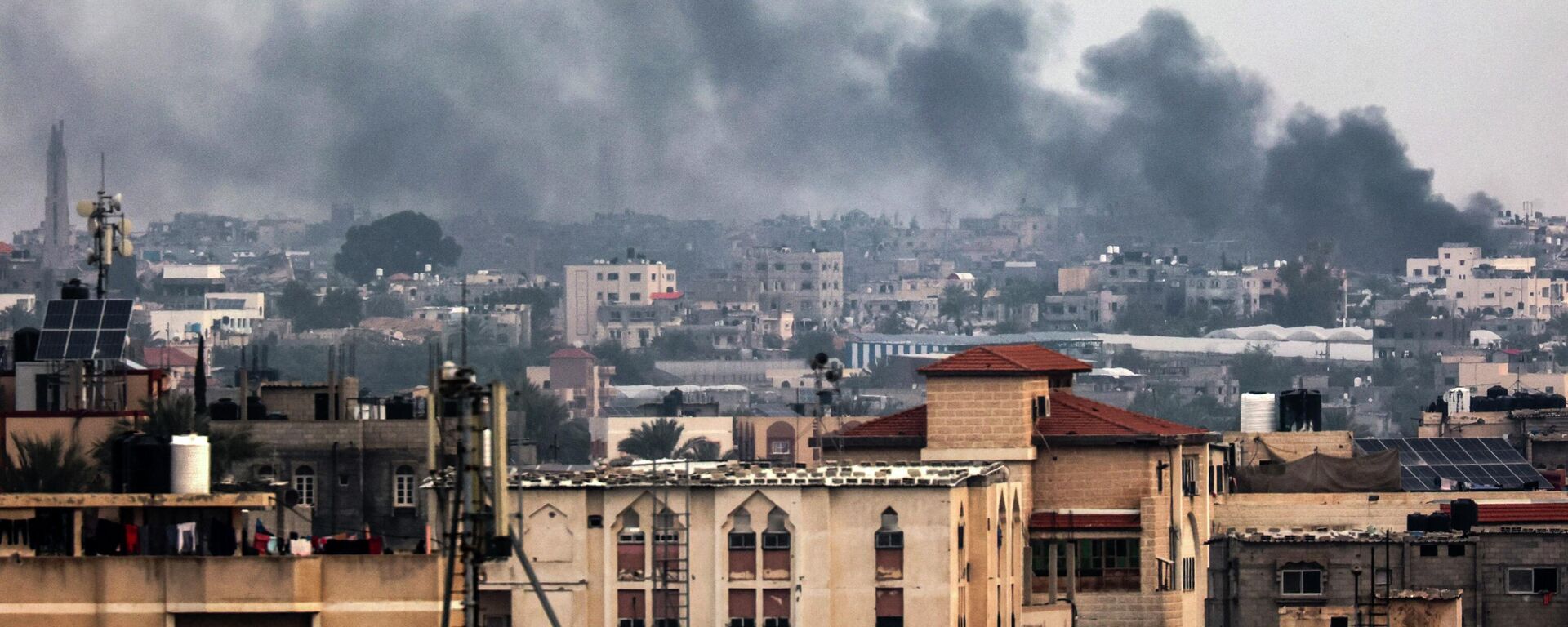 На снимке, сделанном в Рафахе, виден дым, клубящийся над Хан-Юнисом на юге сектора Газа во время израильской бомбардировки  - Sputnik Казахстан, 1920, 25.01.2024