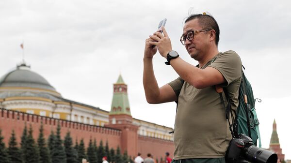 Иностранный турист фотографирует на Красной площади в Москве - Sputnik Казахстан