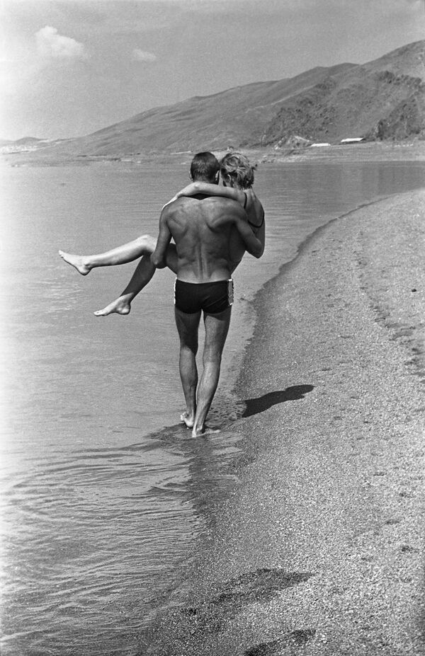 Молодая пара гуляет по пляжу озера Севан, Армянская ССР. - Sputnik Казахстан
