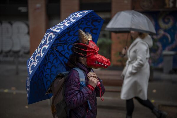 Вот учитель будет рад! На фото: девочка в маске дракона направляется к школе в Барселоне, Испания.  - Sputnik Казахстан