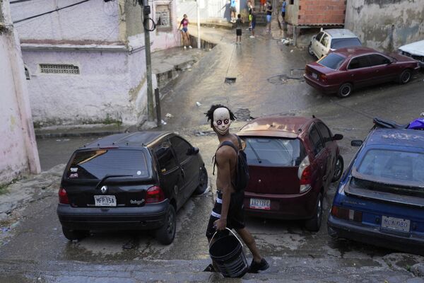 Когда одна примета хуже другой. На фото: человек с пустым ведром и в жутковатой маске идет по улице во время празднования карнавала в Каракасе, Венесуэла. - Sputnik Казахстан