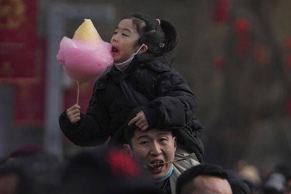 Мужчина несет своего ребенка на плече во время празднования лунного Нового года в Пекине, Китай. - Sputnik Казахстан