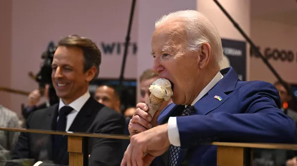Президент США Джо Байден (справа) в сопровождении ведущего Сета Мейерса (слева) ест рожок мороженого в Нью-Йорке, США - Sputnik Казахстан