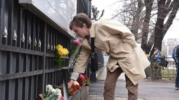 
Казахстанцы несут цветы и свечи к зданию Генконсульства России в Алматы - Sputnik Казахстан