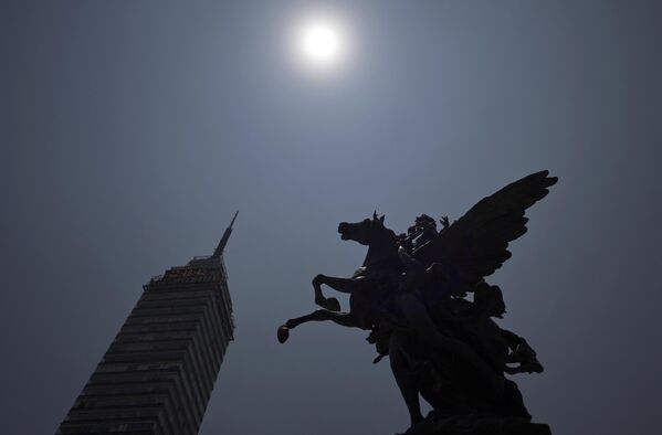 На севере Мексики в 21:17 по московскому времени была видна наибольшая фаза затмения. На фото: вид на башню во время частичного солнечного затмения из Дворца изящных искусств в Мехико. - Sputnik Казахстан