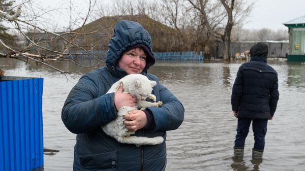 Жительница держит на руках кота в затопленном поселке Покровка, примерно в 90 км от города Петропавловск, на севере Казахстана, недалеко от границы с Россией - Sputnik Казахстан