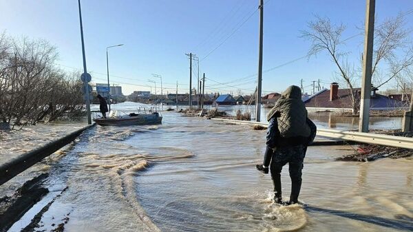 Полицейский выносит ребенка из зоны затопления  - Sputnik Казахстан