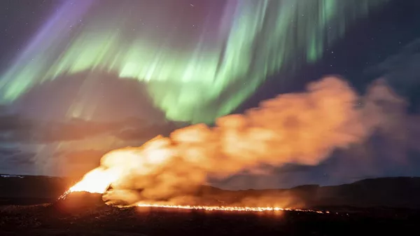 Вид на зону извержения вулкана на фоне северного сияния, Гриндавик, Исландия - Sputnik Казахстан