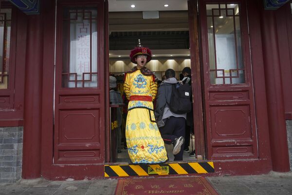 Владелец сувенирного магазина, одетый в старинный костюм, возле Великой Китайской стены на окраине Пекина. - Sputnik Казахстан