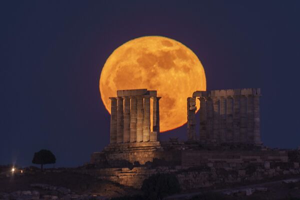 Цветочная луна восходит за древним храмом Посейдона на мысе Сунион, примерно в 70 километрах к югу от Афин, Греция. - Sputnik Казахстан