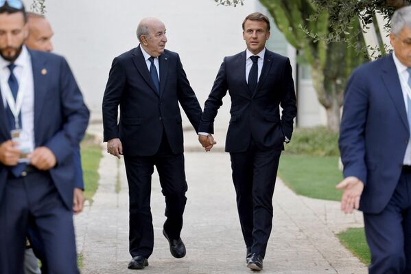 Почти трогательно! На фото: президент Франции Эммануэль Макрон и президент Алжира Абдельмаджид Теббун держатся за руки во время участия в саммите G7 в Италии. - Sputnik Казахстан