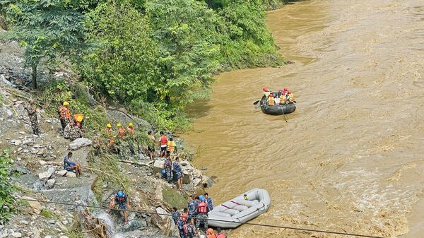Спасатели ищут выживших в реке Тришули в Сималтаре 12 июля 2024 года на месте оползня. По словам властей, по меньшей мере 63 человека пропали без вести в Непале  - Sputnik Казахстан