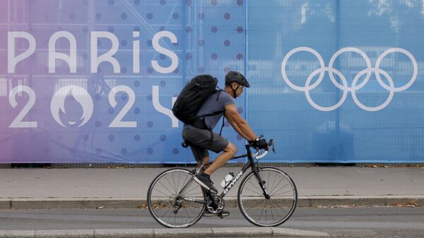 Велосипедист едет вдоль ограждения моста Александра III на олимпийском объекте в Париже 16 июля 2024 года в преддверии Олимпийских и Паралимпийских игр 2024 года в Париже. - Sputnik Казахстан