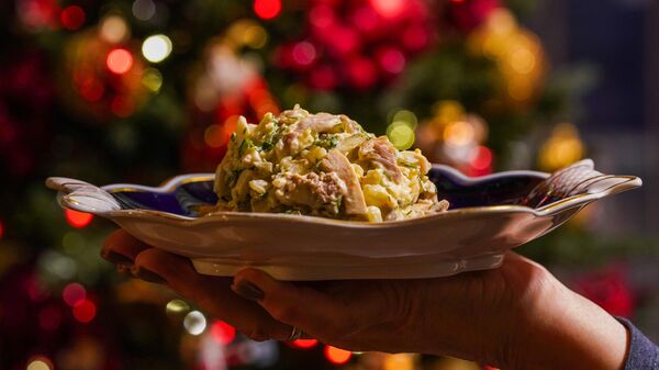 Салат Оливье на фоне новогодней елки - Sputnik Казахстан