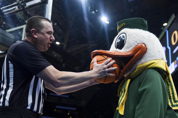 Судья Роб Рорк в шутку дерется с командой Oregon Duck в первом раунде студенческого баскетбольного турнира NCAA в Сиэтле. - Sputnik Казахстан
