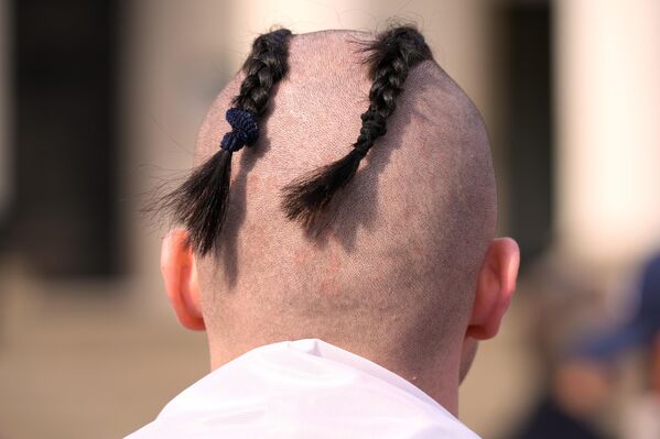 Мужчина с бритой головой и косичками на улице в Варшаве, Польша. - Sputnik Казахстан