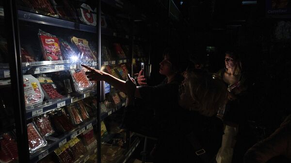 Люди покупают еду в супермаркете во время массового отключения электроэнергии в Памплоне, на севере Испании - Sputnik Казахстан