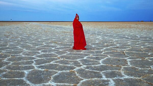 Иранка укрывается одеялом от холода во время посещения соляного озера Хур - Sputnik Казахстан