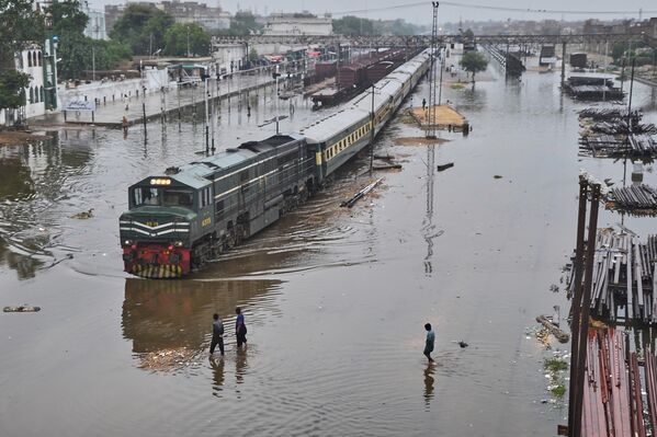 Пригородный поезд отправляется с железнодорожной станции по затопленным путям, Пакистан. - Sputnik Казахстан