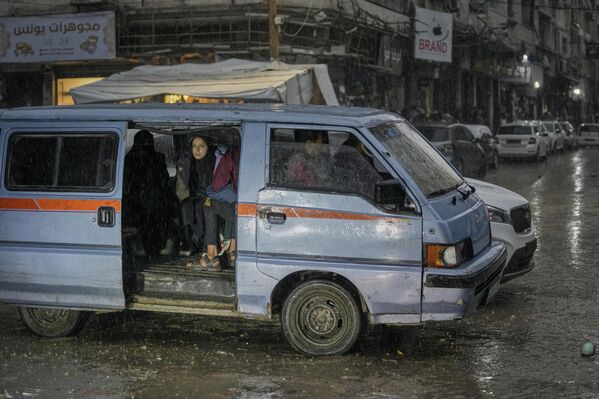 Палестинская семья едет на тележке под дождем, Палестина. - Sputnik Казахстан