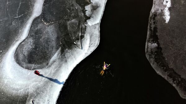 Қытайдың Ляонин провинциясындағы Шэньян қаласында түсірілген бұл суретте қысқы жүзгіш аязды күнге қарамастан өзенде жүзіп жүрген адам бейнеленген. - Sputnik Қазақстан