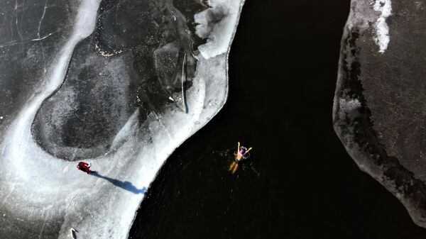 Қытайдың Ляонин провинциясындағы Шэньян қаласында түсірілген бұл әуеден түсірілген көріністе қысқы жүзгіш өзеннің мұзды суларында қатты суыққа төтеп беріп жатыр. - Sputnik Қазақстан