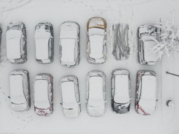 Польшаның Мысленице қаласында қар басқан тұрақта тұр,ған көліктердің көрінісі. - Sputnik Қазақстан