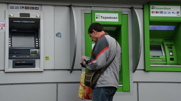 Мужчина у банкомата украинского ПриватБанка, архивное фото - Sputnik Казахстан