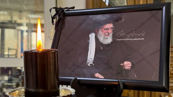 Свечи и Коран рядом с портретом Али Хаменеи в посольстве Ирана в Казахстане - Sputnik Казахстан