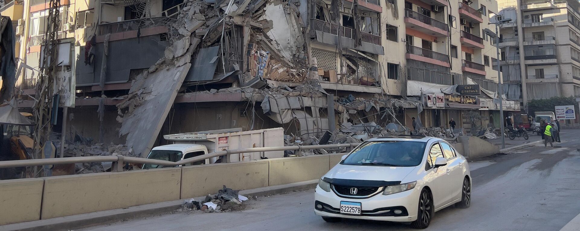 Автомобиль проезжает перед разрушенным зданием, пострадавшим от израильского авиаудара в Дахие, южном пригороде Бейрута, Ливан - Sputnik Казахстан, 1920, 08.04.2026