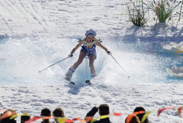 Девушка в праздничном костюме пытается пересечь водоём у подножия склона во время соревнований, Россия. - Sputnik Казахстан