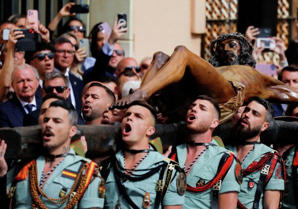 Испанские легионеры несут статую Христа перед церковью во время церемонии перед шествием братства Мена во время Страстной недели в Малаге, Испания. - Sputnik Казахстан