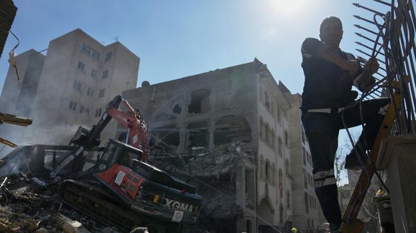 Пожарные и спасатели работают на месте удара, который, по словам сотрудника службы безопасности, находящегося на месте происшествия, разрушил половину синагоги и близлежащие жилые здания в Тегеране, Иран, во вторник, 7 апреля 2026 года - Sputnik Казахстан