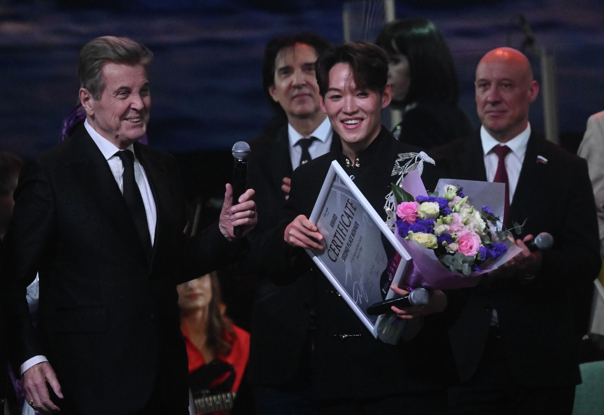 Лев Лещенко (слева) и  Син Кайчжэн (Китай)  с сертификатом за второе место на гала-концерте Международного музыкального конкурса-фестиваля Дорога на Ялту-2026  - Sputnik Казахстан, 1920, 29.04.2026