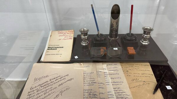 Ал мұнда Бауыржан Момышұлының 1974 жылы Шерхан Мұртазаға жазған хаты, "Мылтықсыз майдан" кітабы, батырдың қолжазбалары мен сиясауыт, қаламсап және көзілдірік сынды жеке заттар топтастырылған. - Sputnik Қазақстан