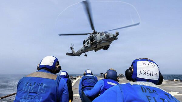 Американские моряки наблюдают за посадкой вертолета MH-60R Sea Hawk на полетную палубу эсминца USS Ross (DDG 71). - Sputnik Казахстан