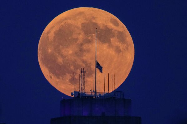 Августовское полнолуние известно как Осетровая Луна (Sturgeon Moon).На фото: полная луна восходит над зданием городской ратуши в центре Канзас-Сити, штат Миссури. - Sputnik Казахстан