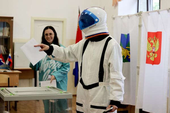 Избиратель в костюме космонавта опускает бюллетень в урну на парламентских выборах во Владивостоке, Россия. - Sputnik Казахстан
