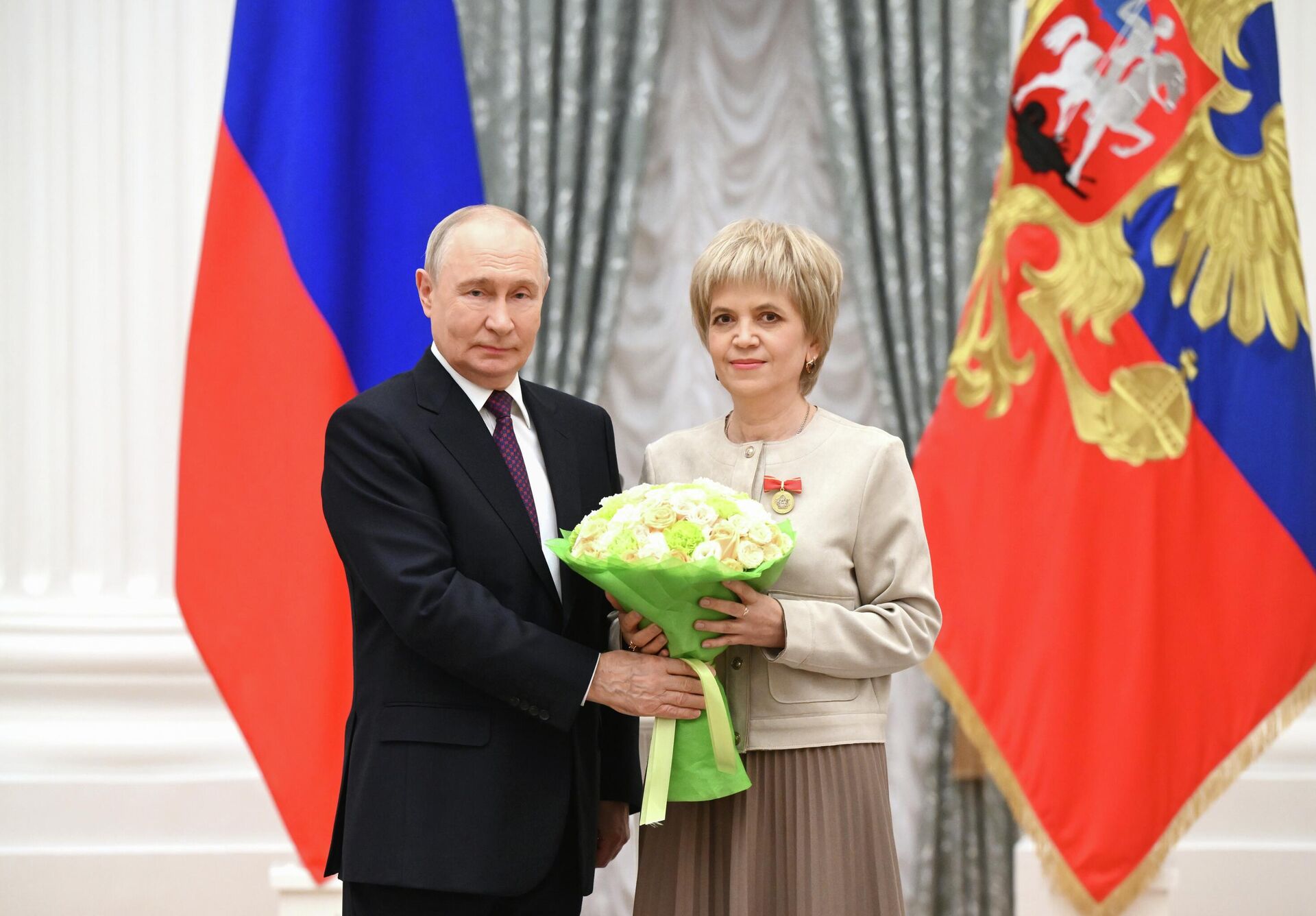 Президент РФ Владимир Путин и замначальника отдела администрации Чистоозерного района Новосибирской области, ранее - учитель русского языка и литературы Чистоозерной средней школы №3 Ирина Сахарова - Sputnik Казахстан, 1920, 05.10.2026