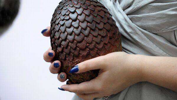 Актриса держит в руках яйцо дракона из сериала Игры престолов, архивное фото - Sputnik Казахстан