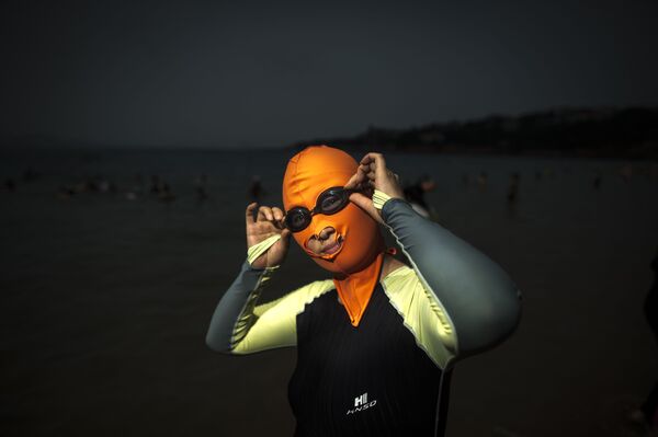 Женщина в маске для купания на пляже в Циндао, 2015 год, Китай - Sputnik Казахстан