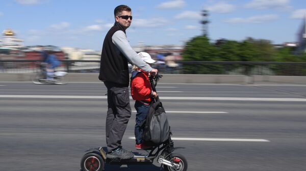 Мужчина с ребенок едут на электросамокате - Sputnik Казахстан