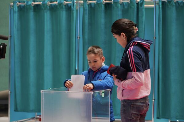 Мальчик кладет избирательный бюллетень вместо совершеннолетней сестры в Нур-Султане - Sputnik Казахстан